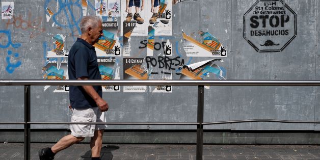 A man walks in front of pro-referendum posters in Santa Coloma de Gramenet on September 16, 2017. / AFP PHOTO / PAU BARRENA (Photo credit should read PAU BARRENA/AFP/Getty Images)