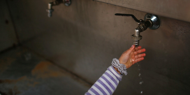 A Palestinian girl uses a public tap to wash her hand in Jabaliya refugee camp in the northern Gaza Strip January 24, 2017. Picture taken January 24, 2017. REUTERS/Mohammed Salem