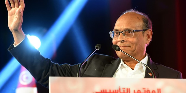 Former Tunisian president Moncef Marzouki waves to his supporters during a rally to launch his new political party Al-Irada (the will) in the capital Tunis on December 20, 2015. Marzouki, a 70-year-old neurologist and founder of the Congress for the Republic party during Ben Ali's long dictatorship, has warned of a 'catastrophic' situation in his country, plagued by poverty and jihadists, as he launched a new party a year after his election defeat. / AFP / FETHI BELAID (Photo credit shoul