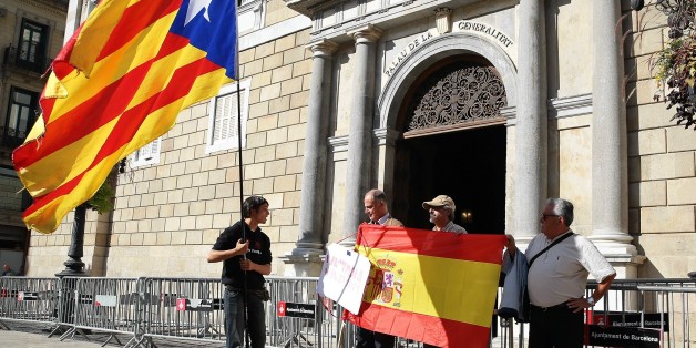 BARCELONA, SPAIN - OCTOBER 30: Some people unfold a Spanish flag as another man waves a Catalan pro-independece flag in front of the 'Generalitat' palace (Catalan government headquarters) in Barcelona on October 30, 2017. Spain enters uncharted and potentially perilous territory today as Madrid moves to take over the running of Catalonia in response to the rebellious region's parliament unilaterally declaring independence. (Photo by Dursun Aydemir/Anadolu Agency/Getty Images)
