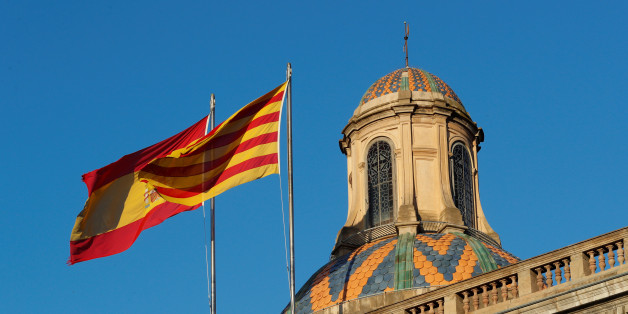 Spanish (L) and Catalan flags flutters atop the Generalitat Palace, the Catalan regional government headquarter in Barcelona, Spain, October 30, 2017. REUTERS/Yves Herman