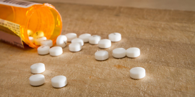 White pills spilled out over some wood