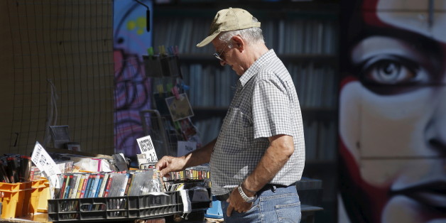 A man looks at used DVDs at a store at Monastiraki area in central Athens, Greece, July 7, 2015. Greece faces a last chance to stay in the euro zone on Tuesday when Prime Minister Alexis Tsipras puts proposals to an emergency euro zone summit after Greek voters resoundingly rejected the austerity terms of a defunct bailout. REUTERS/Christian Hartmann