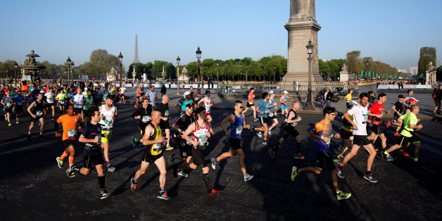 Competitors run down the Champs Elysees below the Arc de Triomphe at the start of the 41st Paris Marathon in Paris, France, April 9, 2017. REUTERS/Benoit Tessier