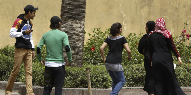 Youth try to harass women on a street in Cairo April 8, 2013. Egypt's National Council for Women (NCW) has proposed a new law against sexual harassment containing a minimum sentence of one-year imprisonment for first-time offenders, local media reported. Picture taken April 8, 2013. REUTERS/Amr Abdallah Dalsh (EGYPT - Tags: POLITICS)