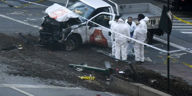 Investigators inspect a truck following a shooting incident in New York on October 31, 2017. Several people were killed and numerous others injured in New York on Tuesday after a vehicle plowed into a pedestrian and bike path in Lower Manhattan, police said. 'The vehicle struck multiple people on the path,' police tweeted. 'The vehicle continued south striking another vehicle. The suspect exited the vehicle displaying imitation firearms & was shot by NYPD.' / AFP PHOTO / DON EMMERT (Photo