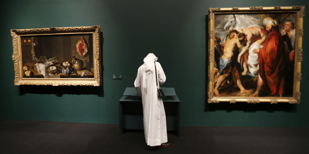 An Emirati visitor stands near a painting (R) by Flemish Baroque painter Jacob Jordaens that is part of 130 artworks featured at the first large-scale presentation of the permanent collection of Abu Dhabi's planned Louvre Museum, at a venue on the Saddiyat Island where the museum will be built off the Emirati capital, on April 21, 2013. The Louvre Abu Dhabi, which opened it's first permanent collection to the public on April 21, is the largest of France's overseas cultural project, Filippetti to