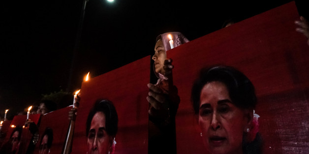 A muslim woman holds candles and portraits of Myanmar's State Counsellor and civilian leader Aung San Suu Kyi during the Interreligious Gathering of Prayer for Peace ceremony in Yangon on October 17, 2017. People attended in Yangon an interfaith rally on October 17, to show unity in a country seared by ethnically-charged violence against the Muslim Rohingya on its western border. Buddhist monks, Christian nuns, Hindus and Muslims were among those who joined the gathering in a display of support