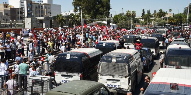 Members of the Tunisian security forces block the road with vehicles along Bardo Square, outside parliament in the capital Tunis on July 6, 2017, calling for the acceleration of the adoption of a law to protect policemen, following the latest attacks against their agents.A Tunisian policeman died on July 1, 2017 from severe burns sustained earlier the week prior when he was hit by a molotov cocktail during clashes in the central Sidi Bouzid region, according to an Interior Ministry statement. /
