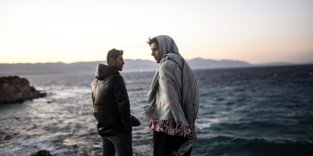 Young men look towards the Greek Chios island as they wait for the wind to calm down to travel on a dinghy with other migrants and refugees from Cesme in the Turkish province of Izmir on November 3, 2015. Amnesty International criticised Europe's failure to stop migrant deaths in the Aegean Sea as the death toll from ramshackle boats sinking off Greece rises daily. The group said over 450 refugees and migrants had died or gone missing in successive Aegean Sea sinkings in the first 10 months of t