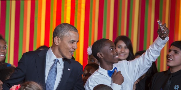A student takes a selfie as US President Barack Obama makes a surprise visit to the White House Talent Show at the White House in Washington, DC, May 20, 2014. AFP PHOTO / Jim WATSON (Photo credit should read JIM WATSON/AFP/Getty Images)