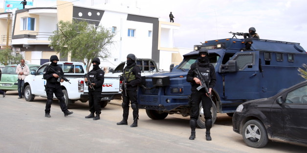 Tunisian police officers stand guard near a cemetery where soldiers and civilians who were killed during Monday's attack on army and police posts by Islamist fighters are buried in the town of Ben Guerdan, Tunisia, near the Libyan border March 9, 2016. REUTERS/Zoubeir Souissi