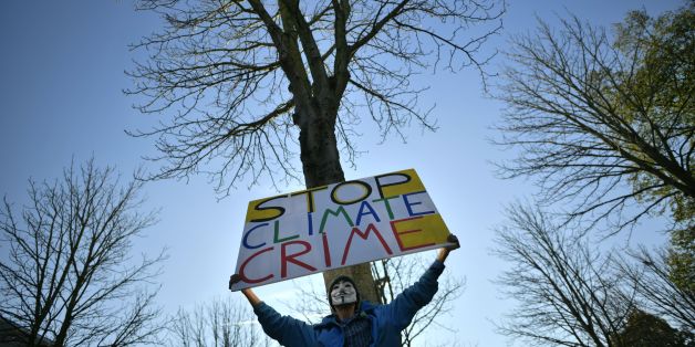 A demonstrator wearing a Guy-Fawkes-mask holds up a poster reading 'Stop Climate Crime' as he takes part in a so-called Climate March against fossil-based energy like coal on November 4, 2017 in Bonn, western Germany.The western city of Bonn will host the UN Climate Change Conference (COP23) from November 6 to 19, 2017, where 'nations of the world will meet to advance the aims and ambitions of the Paris Agreement and achieve progress on its implementation guidelines', according to the organisers