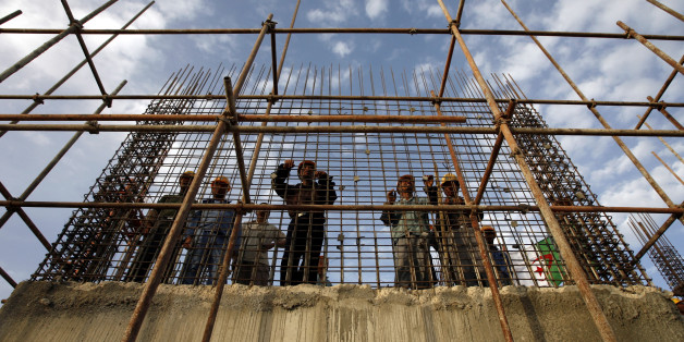 Chinese workers stands behind steel reinforcement at the construction site of a hospital during a visit by Algeria's President Abdelaziz Bouteflika to the city of Setif, 300km (186 miles) from Algiers June 25, 2007. REUTERS/Zohra Bensemra (ALGERIA)