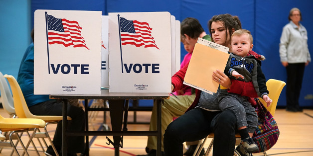 ALEXANDRIA, VA - NOVEMBER 07: Karina Smith holds her 2-year-old son Kyler as she fills out her ballot at the polling place at Washington Mill Elementary School November 7, 2017 in Alexandria, Virginia. All eyes are on Virginia during this off-year election, where Republican Ed Gillespie is running against the commonwealth's current lieutenant governor, Democrat Ralph Northam. (Photo by Chip Somodevilla/Getty Images)