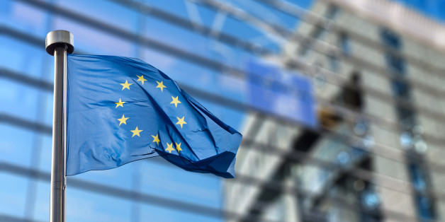 European Union flags in front of the blurred European Parliament in Brussels, Belgium