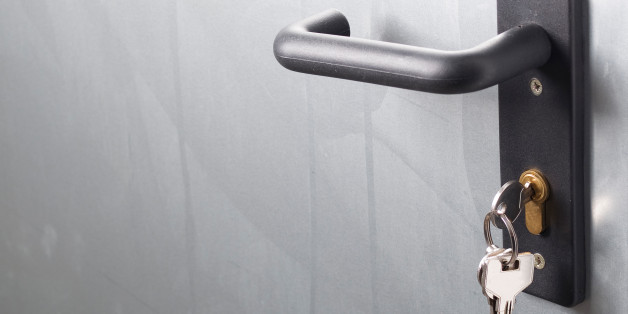 A door handle with lock and keys. The door is metallic.