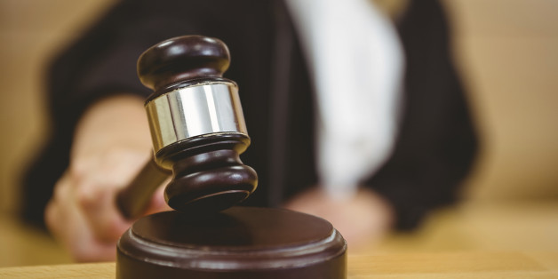 Hand about to bang gavel on sounding block in the court room