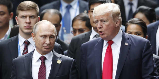 US President Donald Trump (R) and Russia's President Vladimir Putin talk as they make their way to take the 'family photo' during the Asia-Pacific Economic Cooperation (APEC) leaders' summit in the central Vietnamese city of Danang on November 11, 2017.World leaders and senior business figures are gathering in the Vietnamese city of Danang this week for the annual 21-member APEC summit. / AFP PHOTO / POOL / JORGE SILVA (Photo credit should read JORGE SILVA/AFP/Getty Images)