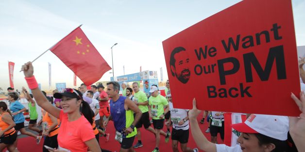 A supporter of Lebanon's resigned prime minister Saad Hariri holds up a placard demanding his return from Saudi Arabia on the starting line of Beirut's annual marathon on November 12, 2017.Hariri announced on November 4 in a televised statement from Riyadh that he would be stepping down from the post, sending shock waves through Lebanese politics. The premier has yet to return to Lebanon and rumours have swirled that he is being held in Saudi Arabia against his will. / AFP PHOTO / ANWAR AMRO
