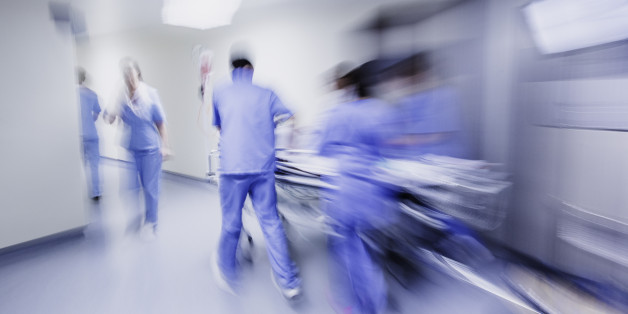 Doctors and nurses pulling hospital trolley,