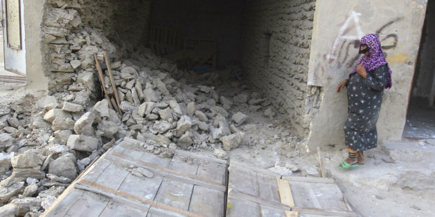 An Iranian woman stands next to the ruins of a house which collapsed during an earthquake in Qeshm Island in the Persian Gulf, 1100 km (684 miles) southeast of Tehran September 10, 2008. A powerful earthquake struck southern Iran on Wednesday near Bandar Abbas, site of a major oil refinery, killing at least four people and injuring 26, officials and state media said. REUTERS/FARS NEWS (IRAN)