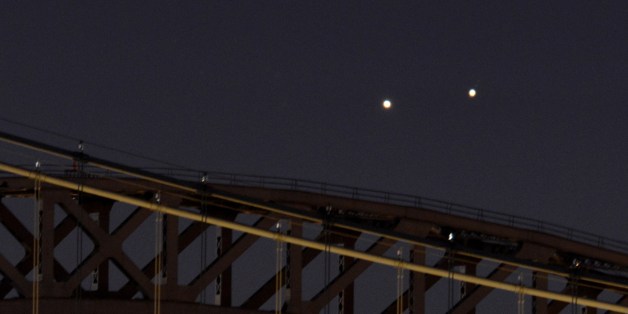 Venus (L) and Jupiter (R) rise together in a rare conjunction over the Hell Gate (rear) and Robert F. Kennedy (front) Bridges in the early morning of August 18, 2014 in New York. The two planets were separated by about 0.25 degrees as viewed from Earth. They will appear farther apart each day but still relatively close together about 45 minutes before sunrise this week. AFP PHOTO/Stan HONDA (Photo credit should read STAN HONDA/AFP/Getty Images)