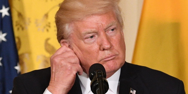 US President Donald Trump adjusts his translation ear piece during a joint press conference with Colombia's President Juan Manuel Santos at the White House on May 18, 2017 in Washington, DC. / AFP PHOTO / JIM WATSON (Photo credit should read JIM WATSON/AFP/Getty Images)