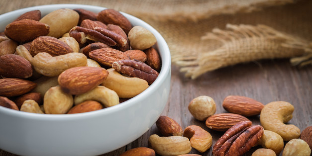 Mixed nuts on wooden table and bowl
