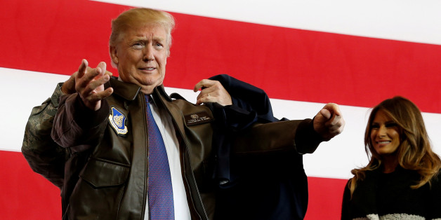 U.S. President Donald Trump puts on a U.S. Pacific Air Forces bomber jacket before delivering remarks to members of the U.S. military at Yokota Air Base, Japan November 5, 2017. REUTERS/Jonathan Ernst TPX IMAGES OF THE DAY