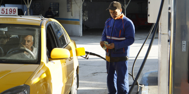 An employee counts money as he fills up a taxi's tank with fuel at a gas station in Tunis March 11, 2013. Protests and strikes planned in Tunisia over the next few weeks will test the government's ability to repair its shaky finances - and may affect its efforts to secure a $1.78 billion loan from the International Monetary Fund. Last week authorities raised most fuel prices for the second time in six months, lifting petrol prices at the pump by 6.8 percent. Taxes on alcohol increased this month