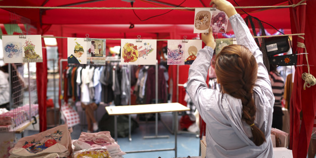 Ho Chi Minh city, Viet Nam - December 10, 2016: A young girl is hanging handmade postcards in the souvenir booth at a flea market in Ho Chi Minh city, Viet Nam
