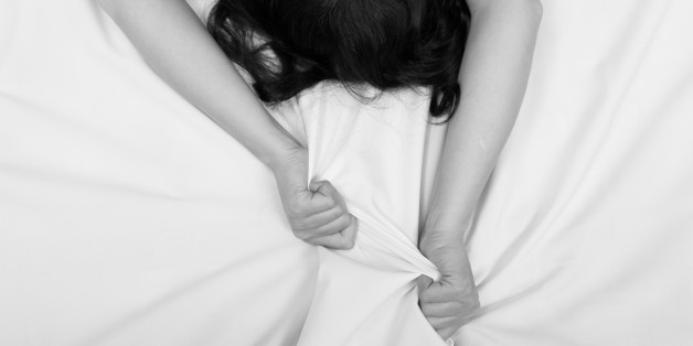 Female hand pulling white sheets in ecstasy, orgasm.