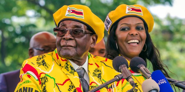 Zimbabwe's President Robert Mugabe (L) addresses party members and supporters gathered at his party headquarters to show support to Grace Mugabe (R) becoming the party's next Vice President after the dismissal of Emerson Mnangagwa November 8 2017.Zimbabwe's sacked vice president, Emmerson Mnangagwa, said on November 8, 2017, he had fled the country, as he issued a direct challenge to long-ruling President Robert Mugabe and his wife Grace. / AFP PHOTO / Jekesai NJIKIZANA (Photo credit shou