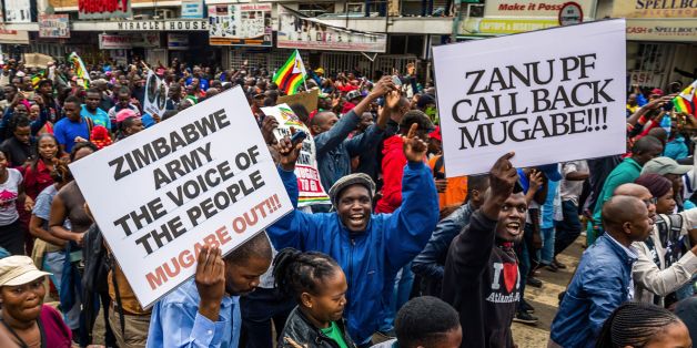 People carry placards during a demonstration demanding the resignation of Zimbabwe's president on November 18, 2017 in Harare.Zimbabwe was set for more political turmoil November 18 with protests planned as veterans of the independence war, activists and ruling party leaders called publicly for President Robert Mugabe to be forced from office. / AFP PHOTO / Jekesai NJIKIZANA (Photo credit should read JEKESAI NJIKIZANA/AFP/Getty Images)
