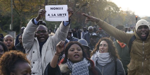 A man holds a placard reading 'No to slavery in Libya' during a march against 'slavery in Libya' on November 18, 2017 in Paris. / AFP PHOTO / GEOFFROY VAN DER HASSELT (Photo credit should read GEOFFROY VAN DER HASSELT/AFP/Getty Images)
