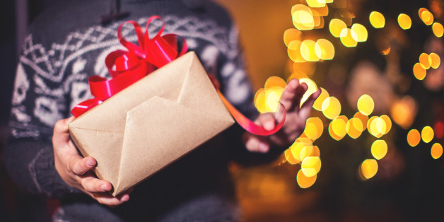 Closeup of child holding holiday gifts,by the Christmas tree