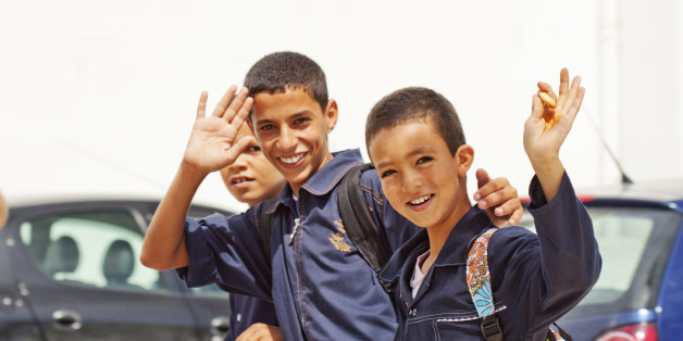 'Nabeul, Tunisia - September 18, 2010: Tunisian school boys are returning to home. They are happy to give a smile to tourists who are taking photos in the streets of Nabeul'