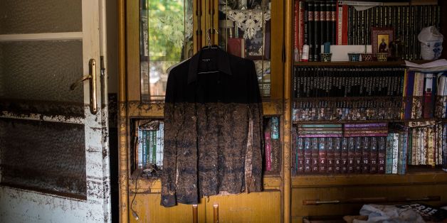 A photo shows a shirt hanging near a bookcase marked with mud from floodwater in a house in Mandra, northwest of Athens, on November 16, 2017, after heavy rainfall caused flooding early on November 15.
Greece was in mourning on November 16 as rescue crews tried to locate several people missing in a flood that killed 15 people near the capital, as rain continued to fall. / AFP PHOTO / Angelos Tzortzinis (Photo credit should read ANGELOS TZORTZINIS/AFP/Getty Images)