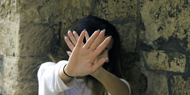 Sad woman after abuse crying under the water in the shower