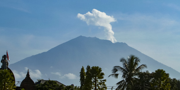 Mount Agung volcano spews steam and smoke into the air as seen from Bangli on Indonesia's resort island of Bali on October 23, 2017.Thousands of residents who fled a rumbling volcano on the island of Bali are refusing to leave evacuation centres after being told to return to their homes outside of the immediate danger zone. / AFP PHOTO / AGUS RANU (Photo credit should read AGUS RANU/AFP/Getty Images)