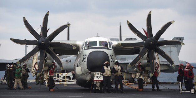 US Navy crew members stand by a C-2 Greyhound on the deck of the Nimitz-class aircraft carrier USS Carl Vinson during a South Korea-US joint military cxercise in seas east of the Korean Peninsula on March 14, 2017.The Carl Vinson Strike Group is participating in the annual joint Foal Eagle exercise between South Korea and the US. / AFP PHOTO / JUNG Yeon-Je (Photo credit should read JUNG YEON-JE/AFP/Getty Images)