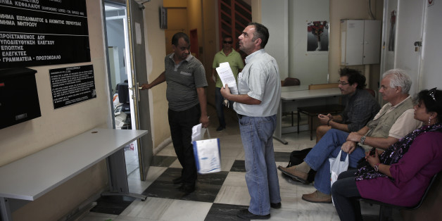 People wait inside a state tax office in central Athens July 2, 2013. Greece has three days to reassure its lenders it can deliver on conditions attached to its international bailout in order to receive the next tranche of aid, four euro zone officials said on Tuesday. There is a general dissatisfaction with progress in Greece when it comes to reforming its public sector, such as tax and custom collection or health care services, a senior euro zone official involved in negotiations said. REUTERS/Yorgos Karahalis (GREECE - Tags: POLITICS BUSINESS SOCIETY)