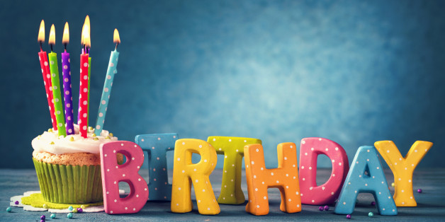 Cupcake with birthday candles on a blue background