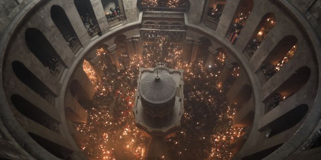 Christian Orthodox worshippers hold candles during the ceremony of the 'Holy Fire' as thousands gather in the Church of the Holy Sepulchre in Jerusalem's Old City, on April 15, 2017, during Orthodox Easter ceremonies.
The ceremony celebrated in the same way for eleven centuries, is marked by the appearance of 'sacred fire' in the two cavities on either side of the Holy Sepulchre. / AFP PHOTO / MENAHEM KAHANA (Photo credit should read MENAHEM KAHANA/AFP/Getty Images)