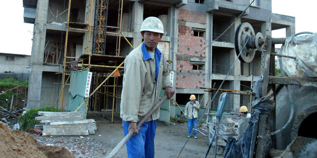 A Chinese labourer works on a construction site in Algiers, March 31, 2004. The Algerian national Agency of Improvement and Development (AADL) has contracted with a Chinese construction company to build some 40,000 appartments within a record delivery time. According to the contract, at least half the appartment buildings must be ready to be inhabited by the end of April 2004. REUTERS/Louafi Larbi LL/MAL/THI