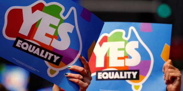 People participating in a march hold aloft posters supporting a 'Yes' vote in a non-binding poll, conducted by post, to inform the government on whether voters want Australia to become the 25th nation to permit same-sex marriage, in central Sydney, Australia, October 21, 2017. Picture taken October 21, 2017. REUTERS/David Gray