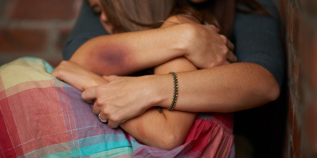 Abused woman embracing her frightened daughter