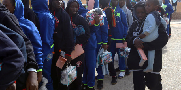 African migrants hold their documents as they gather at a detention centre in the Libyan capital Tripoli on November 28, 2017 ahead of being repatriated to their country of origin under a voluntary program coordinated by the International Organization for Migration (IOM). / AFP PHOTO / MAHMUD TURKIA (Photo credit should read MAHMUD TURKIA/AFP/Getty Images)