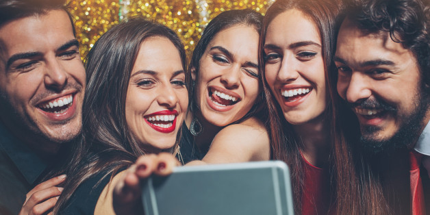 Close up of cheerful group of people on a party making selfie.